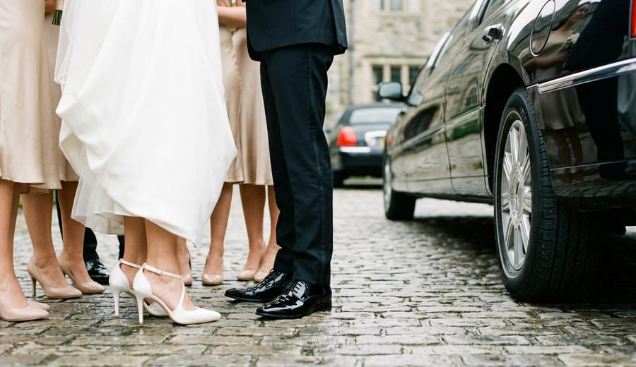 Guests leaving a prom after-party in a black limousine